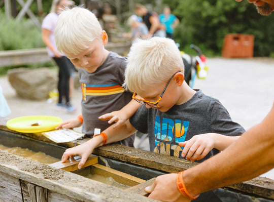 Two young boys sifting for gems