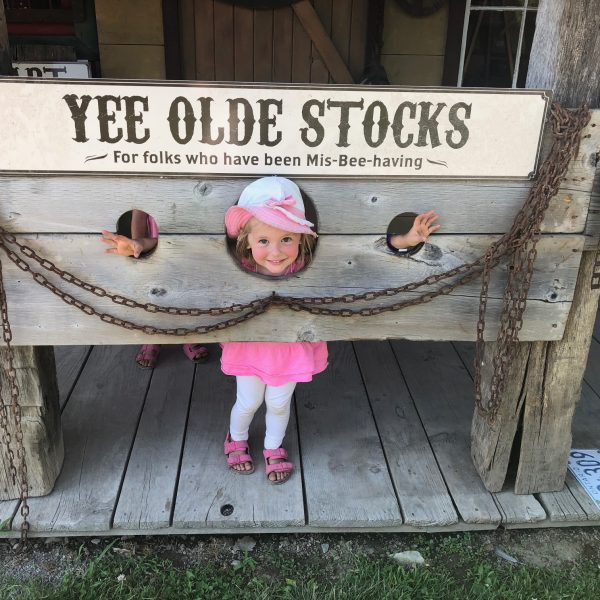 Girl posing in the Yee Olde Stocks